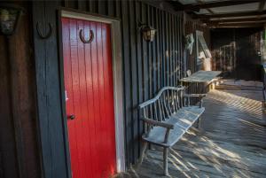 a bench next to a red door on a building at Chum Creek Hut in Chum Creek