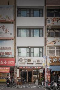 a tall white building with a balcony on it at World Inn 窩二樓小客棧民宿 in Hualien City