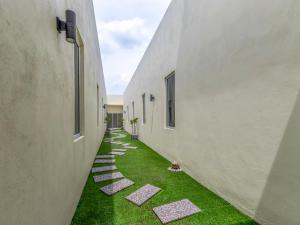 an alley between two buildings with grass between them at Hotel Seri Rembau in Rembau