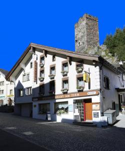 un edificio blanco al lado de una calle en Gasthaus Pension zum Turm, en Hospental