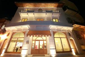 a large white building with doors and windows at night at Villa Palma Boutique Hotel in Panama City