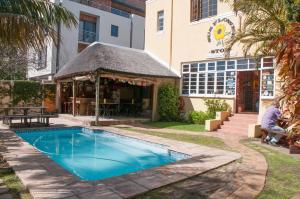 a swimming pool with a gazebo next to a building at A Sunflower Stop Backpackers in Cape Town