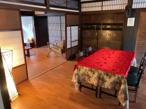 ein Esszimmer mit einem roten Tisch und Stühlen in der Unterkunft Chikubu Yuuan in Nagahama
