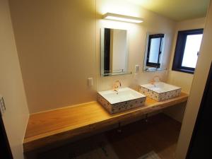 baño con 2 lavabos y espejo grande en Chikubu Yuuan en Nagahama