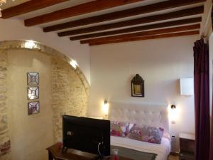 a bedroom with a bed and a tv in a room at Chambre d'hôtes Logis de Saint Jean in Bayeux
