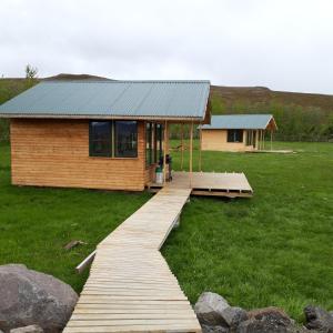a wooden walkway leading to a cabin in a field at Miðhvammur Farm Stay in Aðaldalur