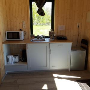 a kitchen with a counter with a microwave and a sink at Miðhvammur Farm Stay in Aðaldalur