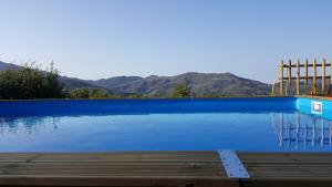 ein Pool mit blauem Wasser und Bergen im Hintergrund in der Unterkunft Villa Levante in Castelbuono