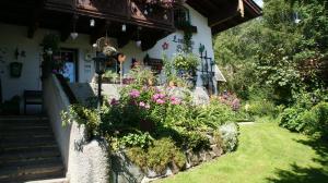 a garden in front of a house with flowers at Landhaus Herzog in Maria Alm am Steinernen Meer