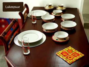 a wooden table with plates and glasses on it at LakeSpace in Boralesgamuwa