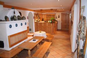 a living room with a table and a kitchen at Alpengasthof-Hotel Kopphütte in Mühlbach am Hochkönig