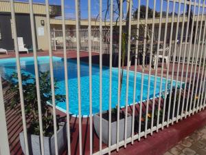 a swimming pool seen through the fence of a building at Desert Sand Motor Inn in Broken Hill