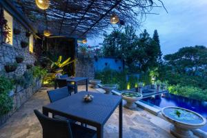 a patio with a table and chairs and a swimming pool at The Theva Residency in Kandy