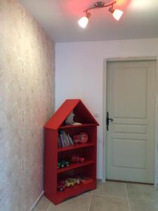 ein rotes Bücherregal in einem Zimmer mit Tür in der Unterkunft Villa Nature 02 in Meunet-sur-Vatan
