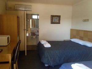 
A bed or beds in a room at Desert Sand Motor Inn
