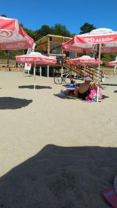 a couple of people laying on the beach under umbrellas at House coffe in Burgas