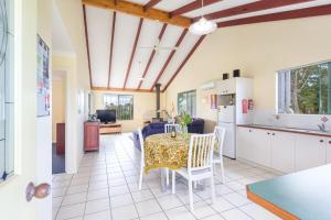 Una cocina y un comedor con mesa y sillas. en Surfside Ocean Beach Denmark Holiday Accommodation, en Denmark