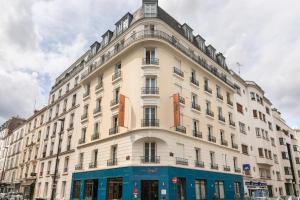 a large white building on a city street at Hotel Boris V. by Happyculture in Levallois-Perret
