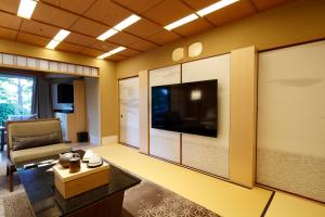 a living room with a large flat screen tv at Hotel Gajoen Tokyo in Tokyo