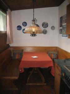 a kitchen with a red table and a chandelier at Appartement am Lift in Saalbach-Hinterglemm