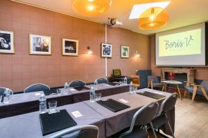 une salle de conférence avec des tables, des chaises et un écran dans l'établissement Hotel Boris V. by Happyculture, à Levallois-Perret