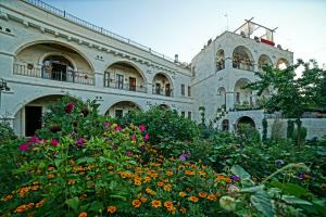 a large building with flowers in front of it at Lucky Cave Hotel Cappadocia in Goreme