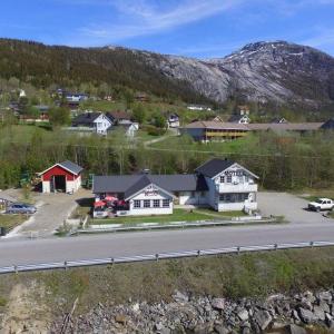 a house on the side of a road next to a mountain at Dalselv hotell in Stien