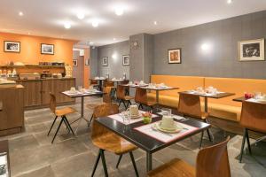 a restaurant with tables and chairs and a counter at Hotel Boris V. by Happyculture in Levallois-Perret