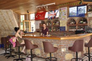 a man and a woman sitting at a bar at Villa Beldeniz in Oludeniz