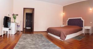 a bedroom with a bed and a flat screen tv at Helen Hotel in Mykolaiv +50 photos