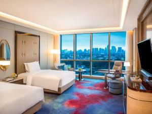 Cette chambre comprend deux lits et une grande fenêtre. dans l'établissement InterContinental Hotels Jakarta Pondok Indah, an IHG Hotel, à Jakarta