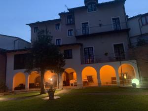 un grand bâtiment blanc avec un arbre en face dans l'établissement Hotel Locanda San Giacomo, à Agliano Terme