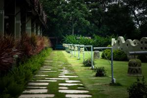 a walkway with stepping stones and plants in a yard at Breathing Earth - Rooms and Pool in Kolkata