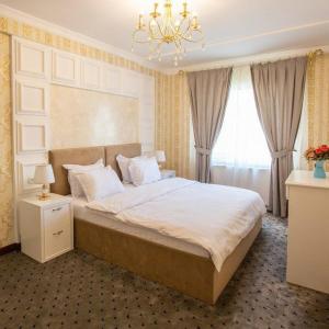 Un dormitorio con una cama grande y una lámpara de araña. en ORZU HOTEL en Namangan