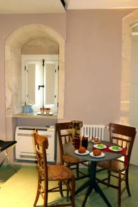 uma sala de jantar com mesa e cadeiras com comida em Casa dei Giurati em Palazzolo Acreide