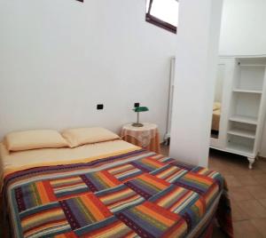 - une chambre avec un lit et une couverture colorée dans l'établissement Remarè Casa vacanze, à Gallipoli
