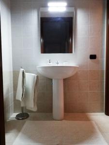 La salle de bains est pourvue d'un lavabo blanc et d'un miroir. dans l'établissement Remarè Casa vacanze, à Gallipoli