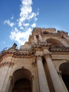 um edifício com colunas e um céu azul em Casa dei Giurati em Palazzolo Acreide