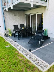 Un patio con sillas y una mesa en una casa. en Ferienwohnung Uferresidenz, en Überlingen