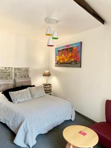 1 dormitorio con 1 cama, 1 mesa y 1 pintura en Appartement des Petits Princes, en Valençay