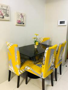 a dining room with yellow chairs and a table at One Palm Tree Villas across NAIA-T3 in Manila