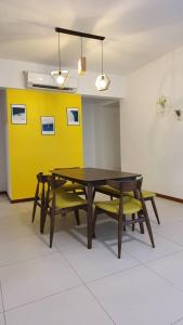 ein Esszimmer mit einem Tisch und 2 gelben Stühlen in der Unterkunft The Landmark by Katana 4BR Luxury Seaview Homestay Gurney无敌海景四房套房 in Tanjong Tokong