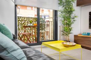 - un salon avec un canapé et une table basse jaune dans l'établissement Stay U-nique Apartments Ricart, à Barcelone