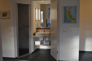 W łazience znajduje się umywalka i lustro. w obiekcie Apartments im Sössaarep's Hüs w mieście Nebel