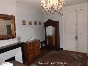 a room with a mirror and a dresser and a chandelier at Maison Porte del Marty in Lalinde