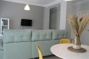 a living room with a blue couch and a table at Las Covachuelas (VuT) in Avila