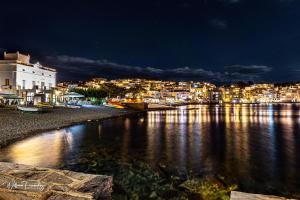 uitzicht op een stad 's nachts met het water bij Hotel La Residencia in Cadaqués