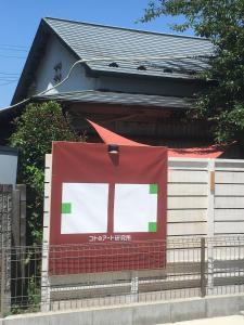 un panneau sur le côté d'un bâtiment dans l'établissement コトのアート研究所, à Ishinomaki