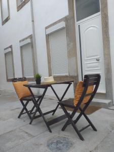 a table and two chairs sitting next to a building at Made in You - Oporto Guesthouse in Porto