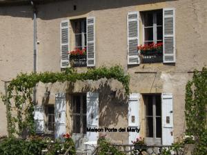 a building with white shutters and flowers on the windows at Maison Porte del Marty in Lalinde